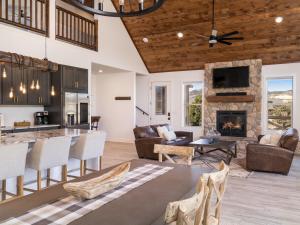 奥德维尔Copper Rock Ridge- Luxury, Pool Table, Hot Tub between Zion and Bryce的开放式客厅设有石制壁炉和厨房。