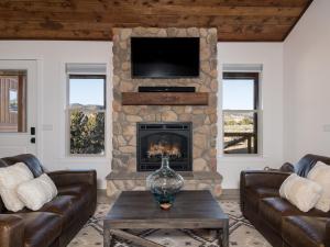 奥德维尔Copper Rock Ridge- Luxury, Pool Table, Hot Tub between Zion and Bryce的带沙发和石制壁炉的客厅