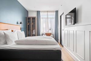 哥本哈根The Huxley Copenhagen, BW Premier Collection的一间卧室配有一张带白色床单的大床