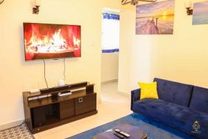 内罗毕Neema Court Jamhuri-woodly的客厅配有蓝色的沙发和电视