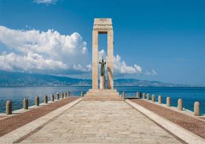 雷焦卡拉布里亚XENIA LUXURY ROOMS的水边码头上的纪念碑