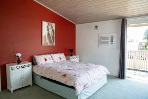 CorryongJardine Lodge - Can sleep 22!的一间卧室设有一张红色墙壁和窗户的床