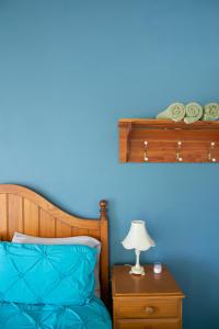 CorryongJardine Lodge - Can sleep 22!的蓝色的卧室配有一张床和一张带台灯的桌子