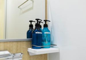大阪鶴橋駅までただ五分間の好立地的浴室内置在架子上的两瓶蓝色瓶子
