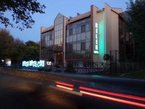 尼古拉耶夫Helen Hotel的街道边有 ⁇ 虹灯标志的建筑物