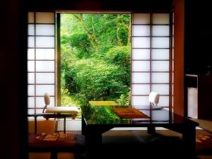 嬉野市大正屋日式旅馆的客房设有一个享有森林美景的窗户。