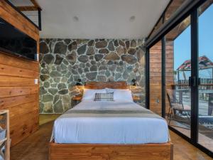 瓜达鲁佩镇Sirius Valle的一间卧室设有一张床和石墙