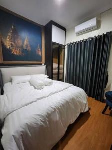 TimuranINEZ Homestay Prawirotaman Yogya的卧室设有一张白色大床和一扇窗户。