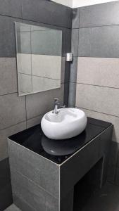 瓦亚纳德Misty Ghats Resort的浴室内黑色柜台上的白色水槽