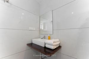 瓦加托Sea View Holiday Vagator的白色的浴室设有水槽和镜子