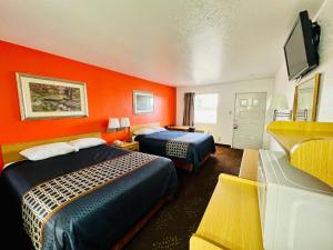 布里奇波特GreyStone Inn的酒店客房带两张床和橙色墙壁