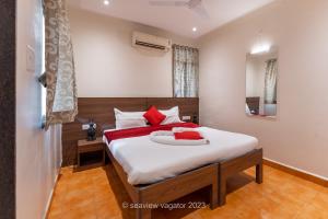 瓦加托Sea View Holiday Vagator的卧室配有带红色枕头的大型白色床