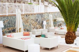 波多黎各阿尔塔玛多里斯酒店的一个带白色沙发和棕榈树的庭院