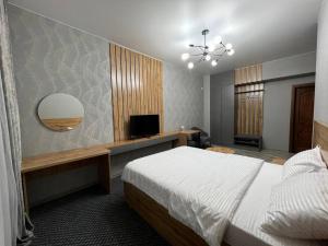 塞米伊Rooms Hotel Semey的一间卧室配有一张床和一台平面电视