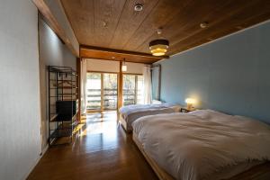 松本NORTHSTAR Loft的配有两张床铺的蓝色墙壁客房