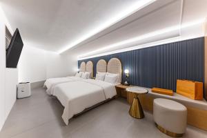 天安市Brown Dot Hotel Cheonan Buldang的酒店客房设有一张白色大床和一张书桌