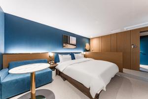 天安市Brown Dot Hotel Cheonan Buldang的酒店客房,设有床铺和蓝色的墙壁