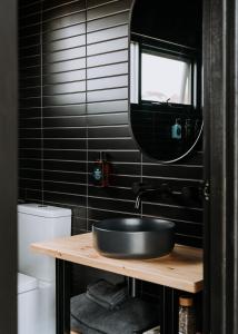 Stokes BayWander on Kangaroo Island的黑色浴室设有水槽和镜子