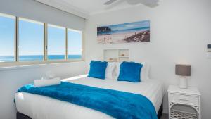 黄金海岸Viscount on the Beach的一间卧室配有一张带蓝色枕头的大床