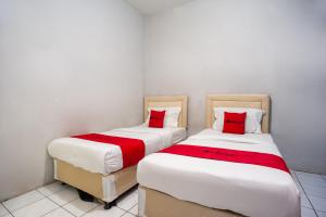 Kemirimuka DuaRedDoorz near Margonda Raya的两张睡床彼此相邻,位于一个房间里