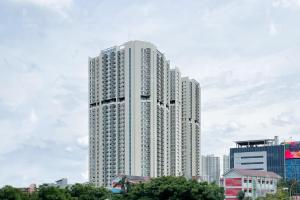 雅加达RedLiving Apartemen Puri Orchard - Prop2GO Home Tower Magnolia的城市中高大的白色建筑