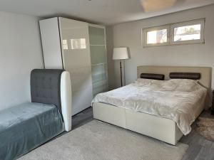 波恩Apartment Meditari Bonn-Muffendorf的卧室配有白色的床和椅子