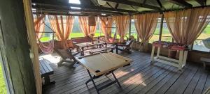 采西斯Vēsturiska viensēta Kārkliņi的木甲板上配有桌椅的房间