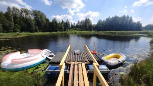 采西斯Vēsturiska viensēta Kārkliņi的三艘船停靠在湖上的一个码头