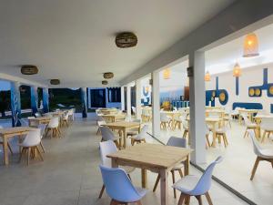 蓬塔杜欧鲁Ponta Mar Resort的餐厅设有木桌、椅子和窗户。