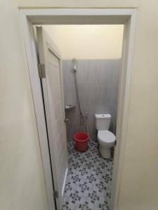 井里汶Anugrah homestay的一间带卫生间和红色桶的浴室