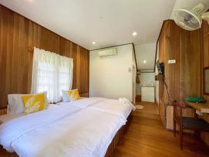 库德岛Mangrove bungalow & restaurant的一间卧室配有两张床和一张书桌