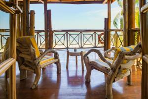 班布里齐瓦海滩度假酒店的阳台的门廊配有2把椅子和1张桌子