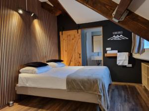 杜柏B&B Barvaux, Durbuy的一间卧室设有一张床和木墙