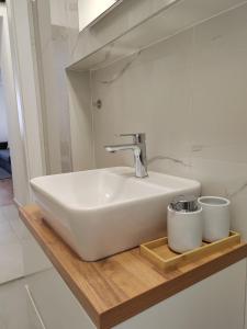 萨格勒布S15 Studio Apartment FREE PARKING的浴室水槽和木架上的2杯水杯