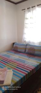 圣维森特Dhadas place的一张带彩色条纹床单和窗户的床