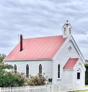 Low HeadLow Head Pilot Station的白色的教堂,有红色的屋顶,有白色的栅栏