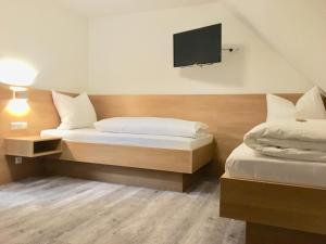 乌尔姆恩格尔酒店的一间卧室配有两张床和一台平面电视