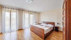加茨比亚格拉Apartamenty Sun & Snow Rozewie的一间卧室配有一张带木制床头板的床和大窗户