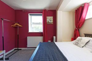 马盖特Garden Oasis的红色的卧室设有床和窗户