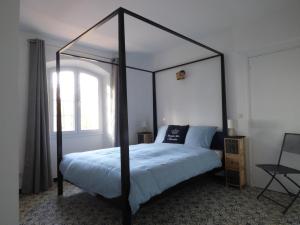 新堡Apartment Cézanne mit geheiztem Pool und Privatgarten的一间卧室配有一张黑色天蓬床和窗户
