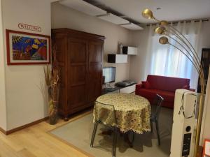 维罗纳Appartamento EmmeRosa, centro città, parcheggio的客厅配有桌子和红色沙发