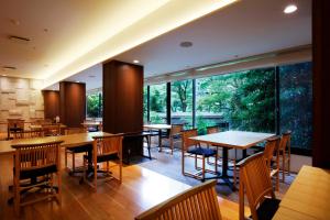箱根吉池日式旅馆的餐厅设有桌椅和大窗户。