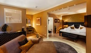 梅尔斯堡罗曼蒂克安西住所酒店的客厅配有沙发和一张位于房间的床