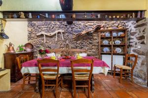 托尔纳瓦卡斯Antigua Posada, Valle del Jerte的一间设有一张桌子和石墙的用餐室