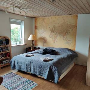 SpottrupVidunderligt hus i landlige omgivelser的卧室配有一张大床,墙上挂有地图