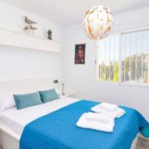 阿尔啼magnifique villa 6 personnes Altéa paradiso的卧室配有蓝色和白色的床,提供毛巾