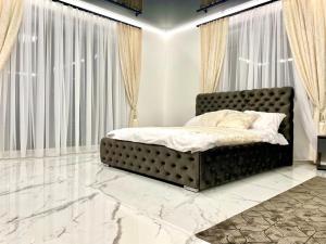 里加GRAND APARTMENT BALTEZERS的一间卧室配有一张大床,铺有大理石地板,设有窗户。