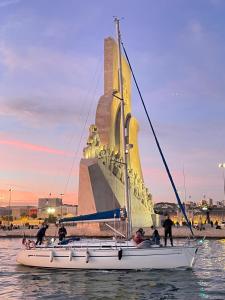 里斯本Veleiro Oceanico de 12 m的雕像前水面上的帆船