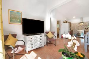 圣巴托洛梅乌迪梅西尼什Casa Arcadia T3的一间客厅,客厅内配有白色梳妆台上的电视