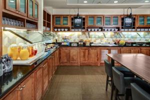 奥罗拉丹佛机场凯悦嘉轩酒店的一个带木制橱柜和酒吧的大厨房